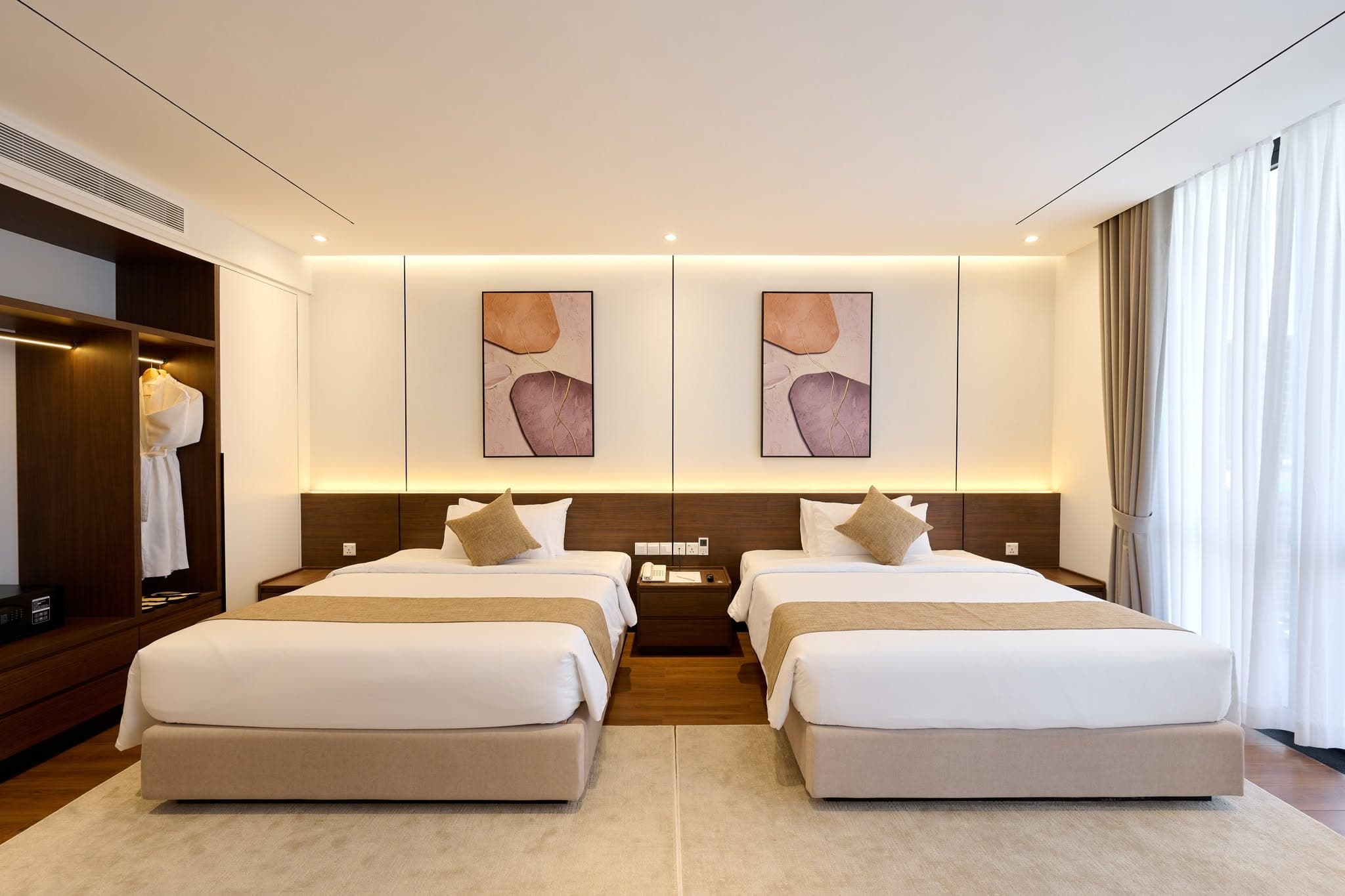 Twin beds and warm lighting in an Osea guest room